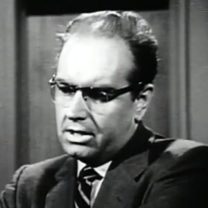 Television still of actor Parley Baer wearing glasses, suit and tie